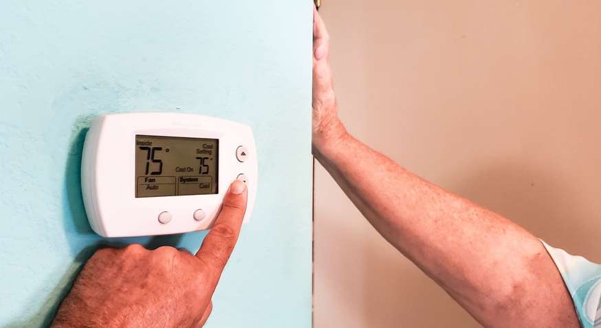 homeowner-adjusting-thermostat